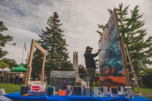 Artist creating large painting outside