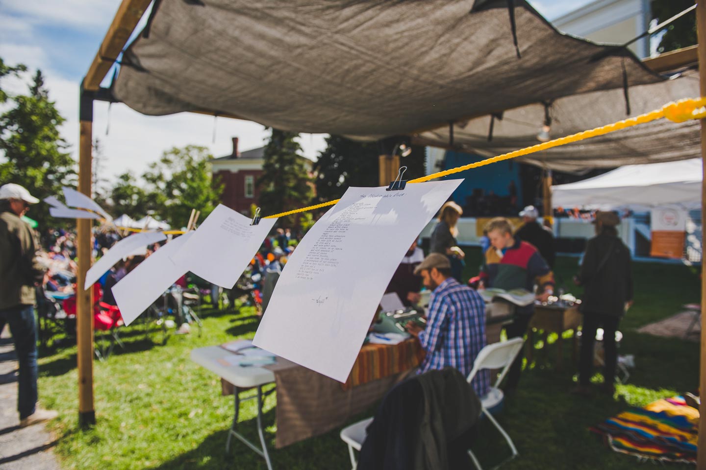 Papers blowing in the wind on a clothesline, while participants use old typewriters