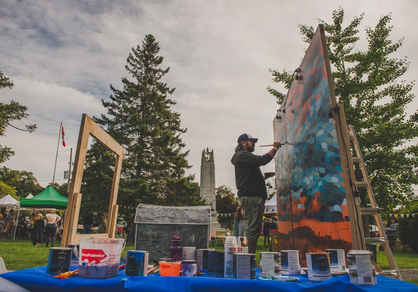 Artist creating large painting outside