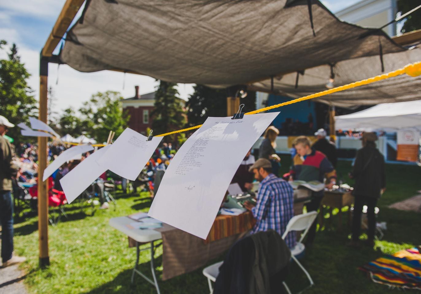 Papers blowing in the wind on a clothesline, while participants use old typewriters